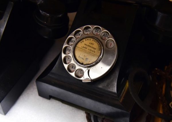 two bakelite telephones on a white shelf