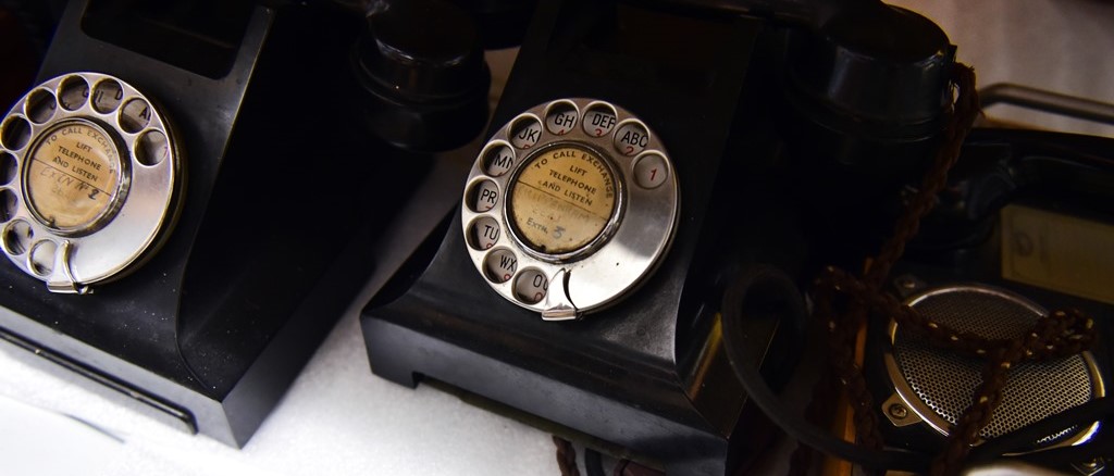 two bakelite telephones on a white shelf