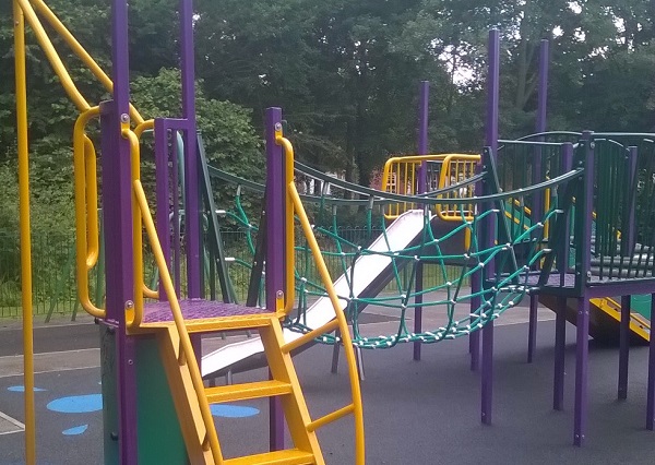 A yellow and purple climbing frame in a play park