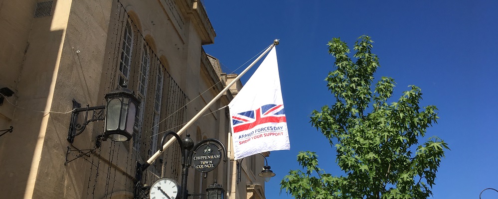 Armed Forces Day flag flown at the Town Hall which reads 'Armed Forces Day, show your support' in blue and red writing on a white flag