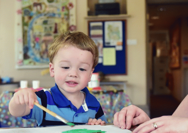 under five and adult enjoying painting a picture