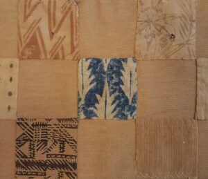5 squares of printed textiles on a brown fabric background