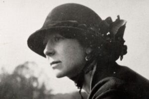 head and shoulders portrait photograph of a women in a brimmed hat