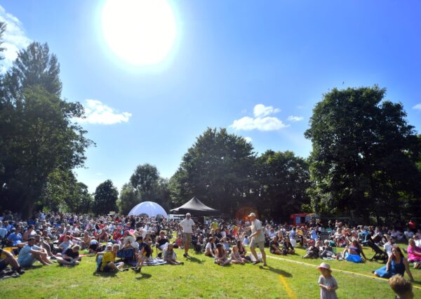 Party in the Park Crowd 2024 Photograph of people gathered in john coles park sat on the green grass with the sun shining and a blue sky
