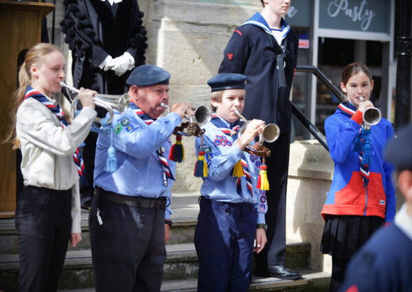 Photograph of 4 people in uniform playing musical instruments