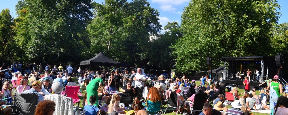 Donations Photograph of lots of people sat down in the sun with camping chairs