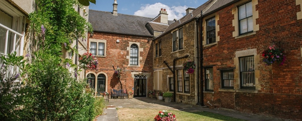 Twinning Photograph of houses with flower pots hanging up outside