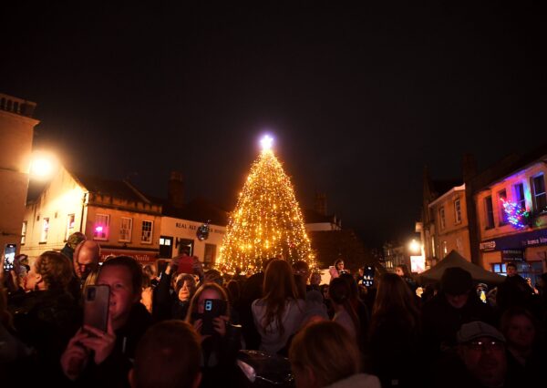 Christmas Tree 2024 An outdoor lit up Christmas tree, surrounded by a crowd of people.