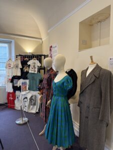 Twelfth Night 2025 Costume display of t-shirts, dressed, and jackets.