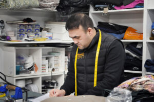 Man working in local tailoring shop called Stitch Express. Man working in local tailoring shop called Stitch Express.