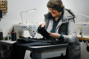 Woman sewing in local tailoring shop called Stitch Express.