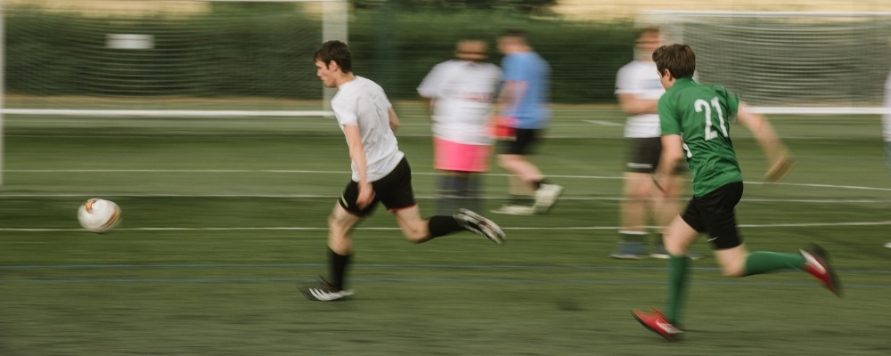 Stanley Park running football players A dynamic shot of footballers on the pitch at Stanley Park Sports Ground