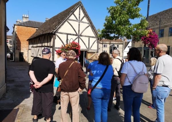 Engagement Volunteer A group of visitors, on a town walk, standing outside the Yelde Hall in the sunshine.