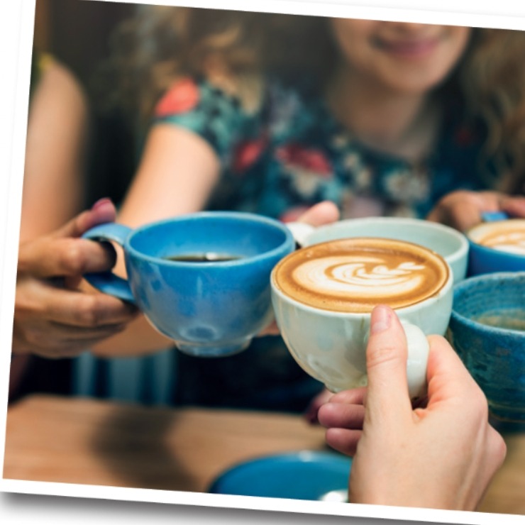 two coffee cups raising their mugs to cheers