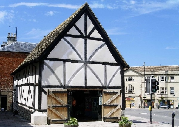 Medieval building with white plaster and black beams and large wooden doors