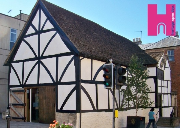 A picture of Chippenham's medieval Yelde Hall, a black timber and white plaster building with large wooden doors.